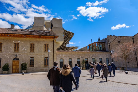 Elciego, Álava, Spain. April 23, 2018: Stone buildings of a wine cellar of the Rioja called Marqués de Rsical with many people heading insideのeditorial素材