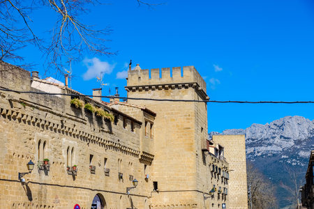Detail of the battlements and walls with small windows of the walls that defended the town of Laguardia, in the Rioja Alavesa (Alava, Spain) with large stone ashlars and a large mountain in the backgroundのeditorial素材
