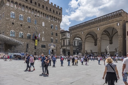 Florence, Italy. June 1, 2018: Square called of the Signoria with view to the palace called Vecchio and the building of arches called Loggia dei Lanzi full of statues. Many tourists in the squareのeditorial素材