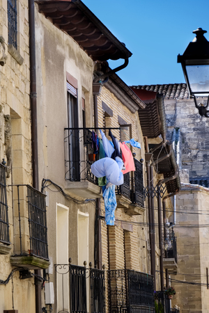 Detail of an iron balcony with clothes hanging to dry in a stone house typical of the villages of northern Spainの写真素材