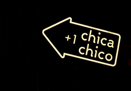 Luminous yellow arrow of neon with sign girl boy on black background