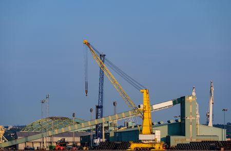 Heavy crane and buildings and industrial warehouses in port facilitiesの写真素材