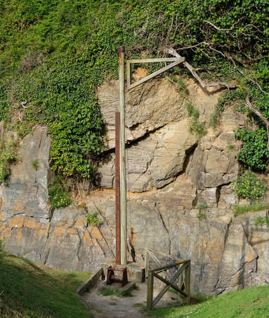 Old manual crane already rusted and in disuse, used to hoist the boats to the mainland and located on a cliffの写真素材