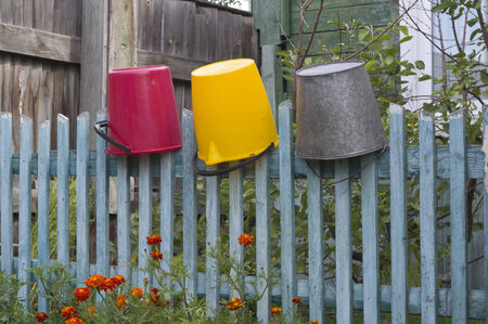 Village paling with three suspended bucketsの写真素材