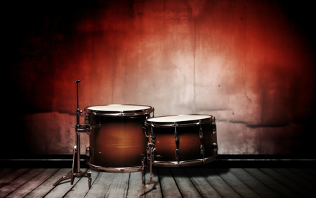 Drum set on wooden floor in dark room with red light.の素材