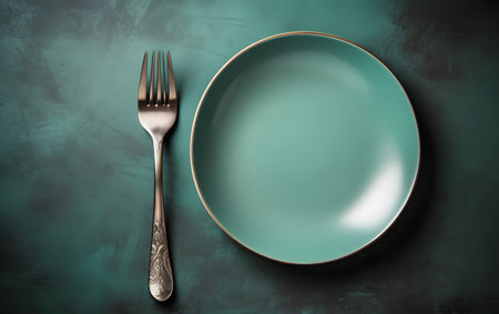 Empty green plate with fork and knife on grunge background. Toned.の素材