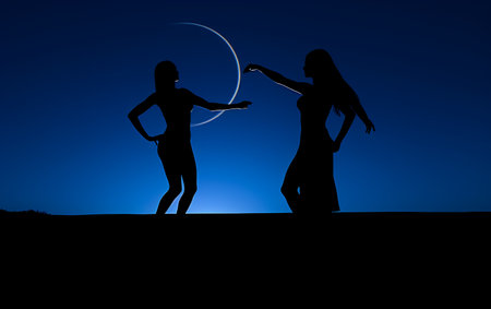 Silhouette of two young women dancing in the moonlight.の素材