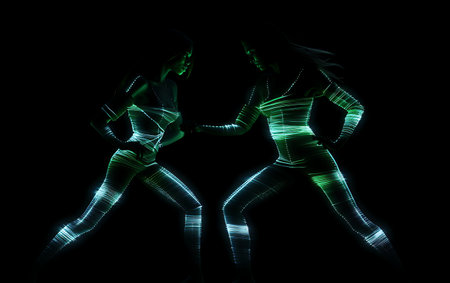 Two female athletes running against black background with green neon light. mixed-mediaの素材