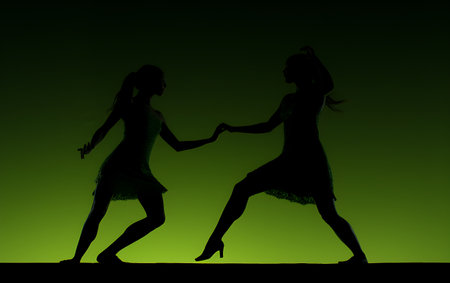 Silhouette of two women dancing flamenco on green backgroundの素材