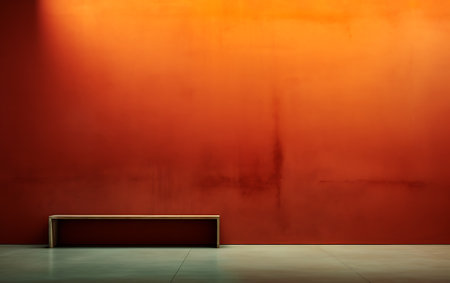 Empty wooden bench in front of a red wall with copy space.の素材
