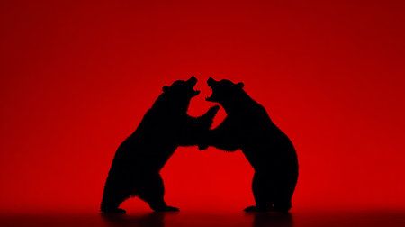 Silhouette of two bears fighting each other on a red backgroundの素材