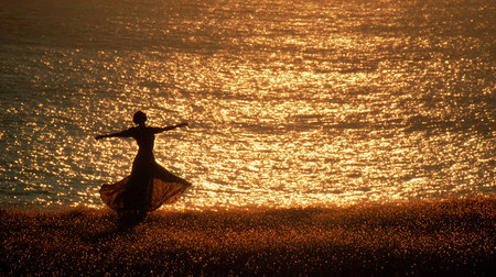 Silhouette of a woman dancing on the beach at sunset.の素材
