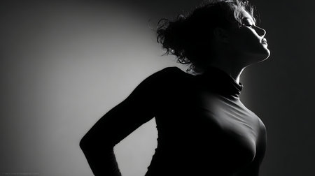 silhouette of a beautiful woman in a black dress on a gray backgroundの素材