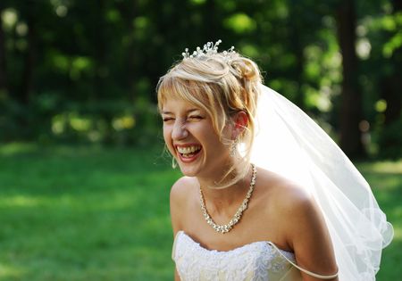 Bride laughing expressively on the meadow during the photo session.の写真素材