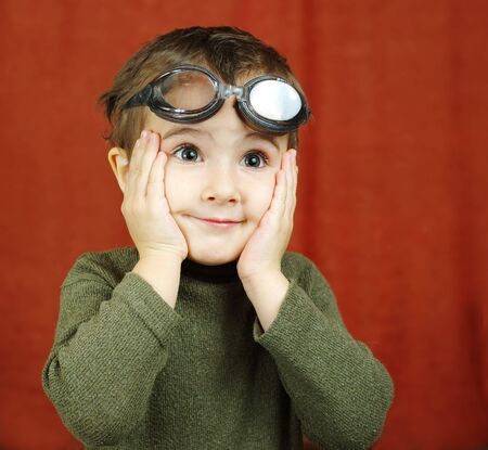 Small boy in swimming glasses pretends to be a pilot wonderingの写真素材
