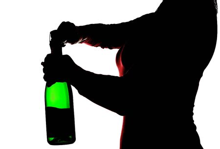Silhouette of the woman with green bottle in hands opening champagne, isolated on whiteの写真素材