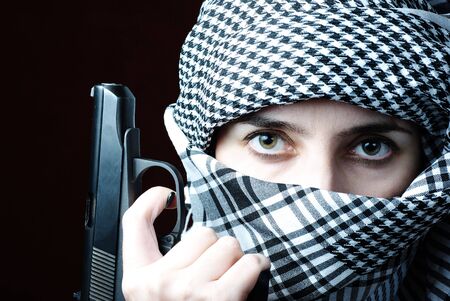 Arab woman eyes in keffiyeh with gunの写真素材
