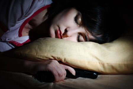 Women sleeps with the gun under the pillowの写真素材