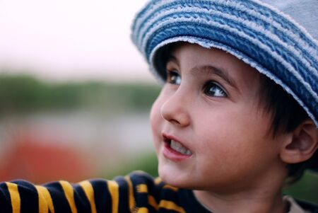 Little boy in jeans hat plays the game outdoorsの写真素材