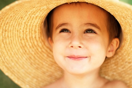 Little boy in straw hat with hude brim outdoorsの写真素材
