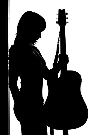 Silhouette of woman with guitar isolated on whiteの写真素材
