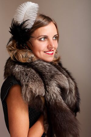 Retro woman with feather and fur profile portraitの写真素材