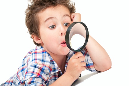 Surprised little boy with weird hair and magnifier isolated on whiteの写真素材