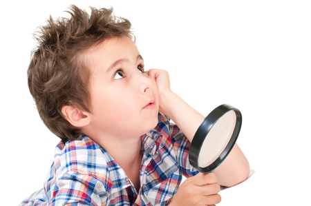 Dreamy little researcher boy with weird hair and magnifier isolated on whiteの写真素材