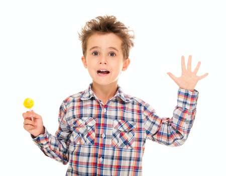 Little boy wave goodbye with lollipop in hand isolated on white の写真素材