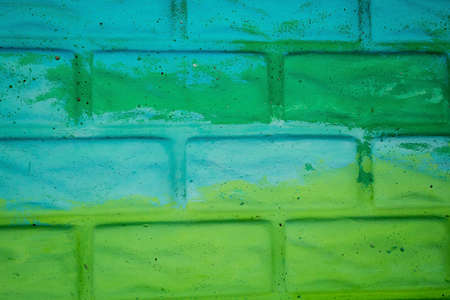 Yellow and green painted brick wallの写真素材