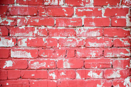 Red brick wall with peeling white paintの写真素材