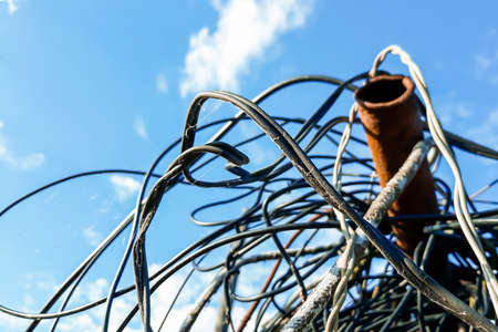 Skein of old wire on a background of blue skyの写真素材