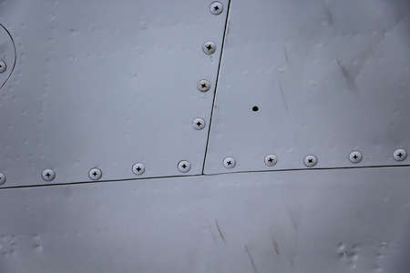 Aircraft skin close up. Rivets on gray metal. Background for design.の写真素材