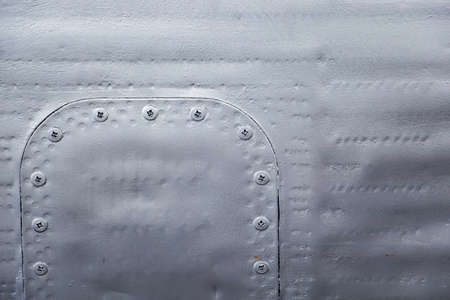 Aircraft skin close up. Rivets on gray metal. Background for design.の写真素材