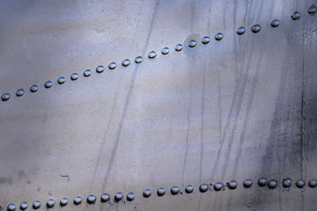 Aircraft skin close up. Rivets on gray metal. Background for design.の写真素材