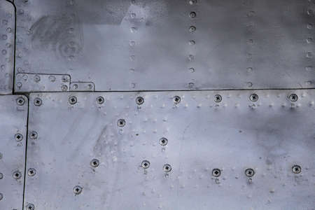 Aircraft skin close up. Rivets on gray metal. Aluminum textureの写真素材