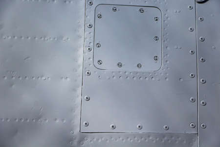 Aircraft skin close up. Rivets on gray metal. Aluminum textureの写真素材
