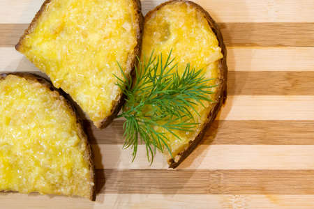 Hot sandwiches with melted cheese and herbs on wooden background