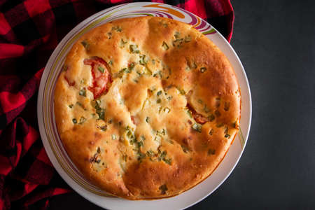 A piece of cake with chicken, herbs and tomatoes on a plate. Homemade delicious food for diet.
