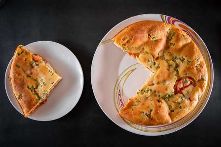 A piece of cake with chicken, herbs and tomatoes on a plate. Homemade delicious food for diet.