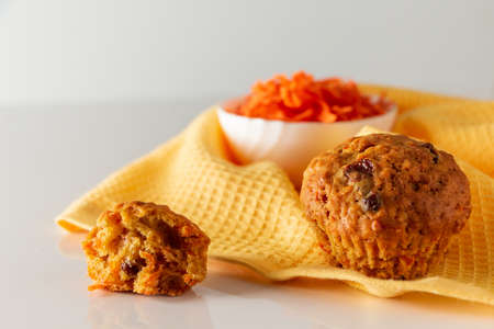 Tasty carrot muffins on a white background. Homemade cakes on a yellow napkin.