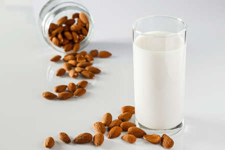 A glass of almond milk on a white background. Lactose-free vegetable diet milk. Gluten free almond...
