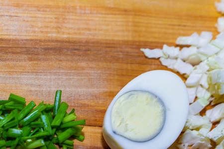 The process of preparing a delicious salad for a healthy diet. Salad ingredients and knife on a wooden background.の写真素材