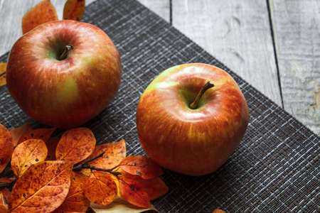 Ripe autumn apples on a background of orange leaves