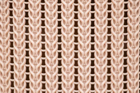 The texture of a yellow plastic wicker basket closeup.