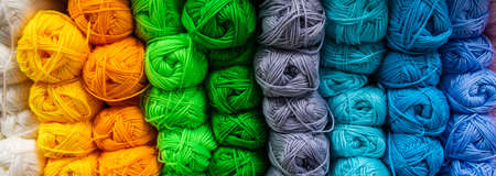 Many balls of wool yarn for knitting. Selling fluffy threads in a craft store. Banner format