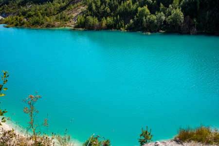 Beautiful landscape - a mountain lake with unusual bright turquoise water. Stone coast with green...