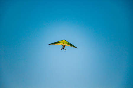 Hang glider in the blue sky. Extreme dangerous sport, air flights.の写真素材