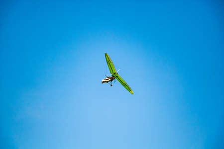 Hang glider in the blue sky. Extreme dangerous sport, air flights.の写真素材