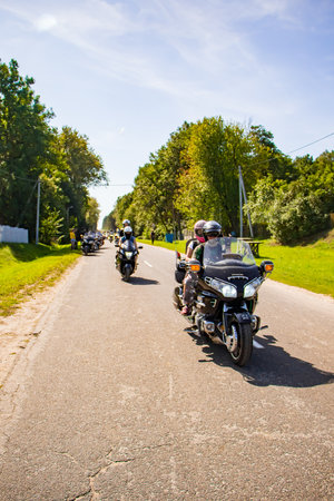 Motorcyclist rides on the road on a sunny summer day. A column of motorcycles goes to a motor festival: 08.24.2019 - Lida, Belarus.のeditorial素材